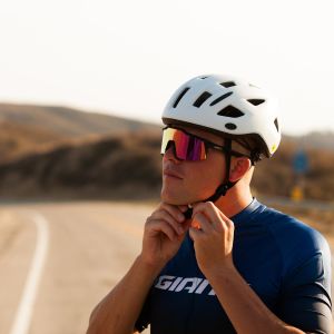 Road cyclist putting on helmet
