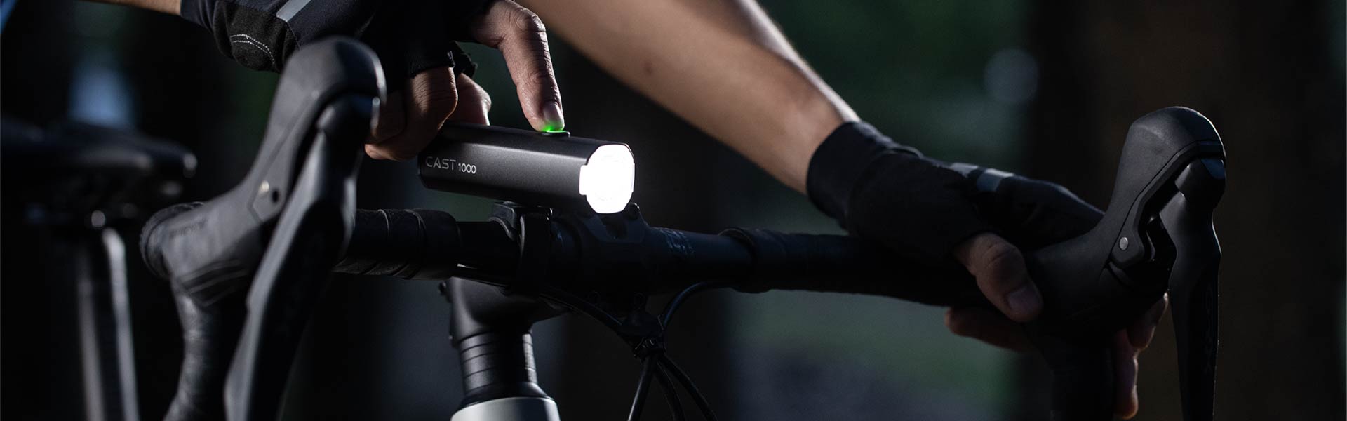 Cyclist switching on a headlight mounted to bike